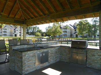 an outdoor kitchen with a grill  and sink